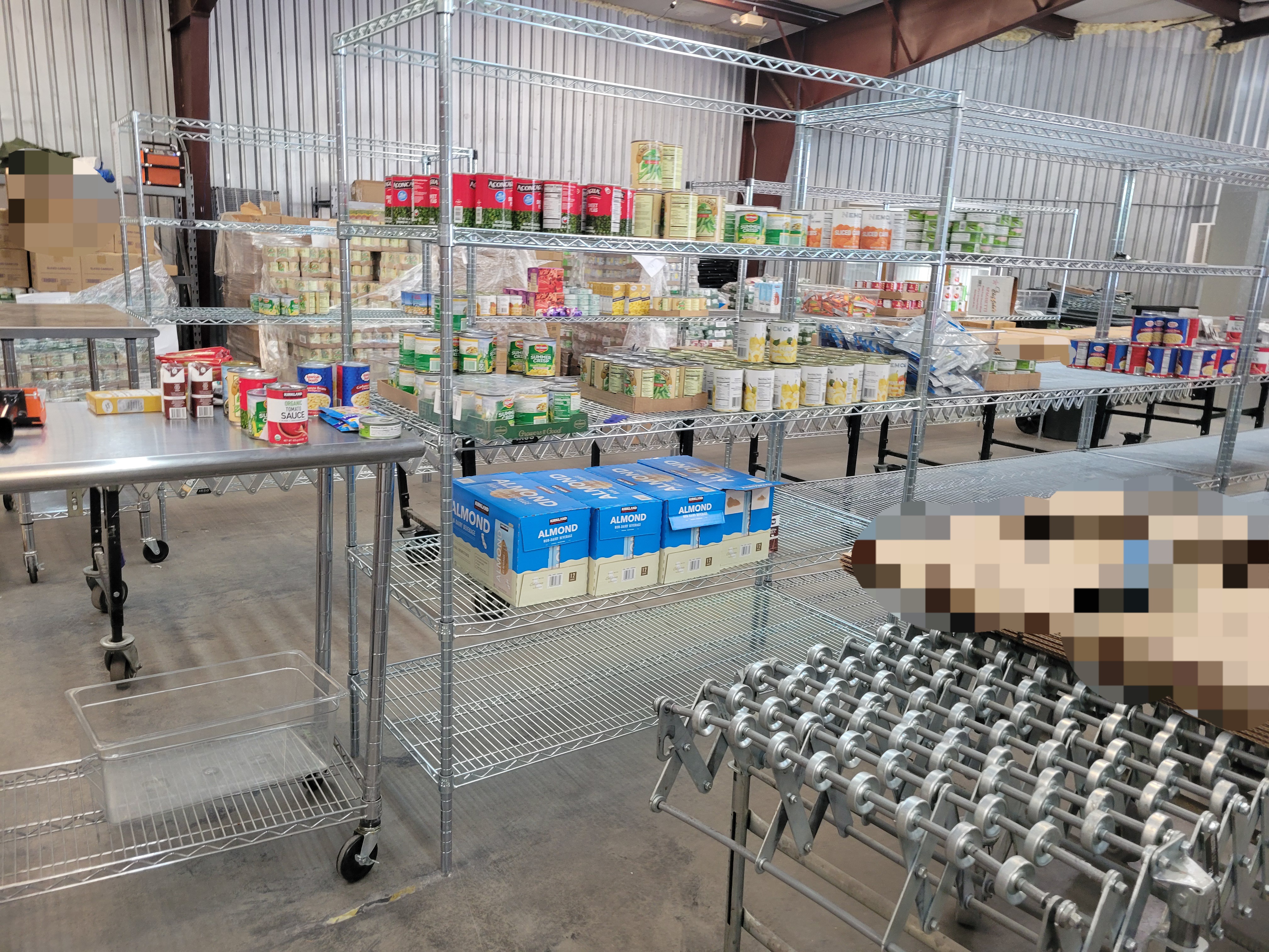 Boxes on the conveyor belt with product filled shelves behind it.